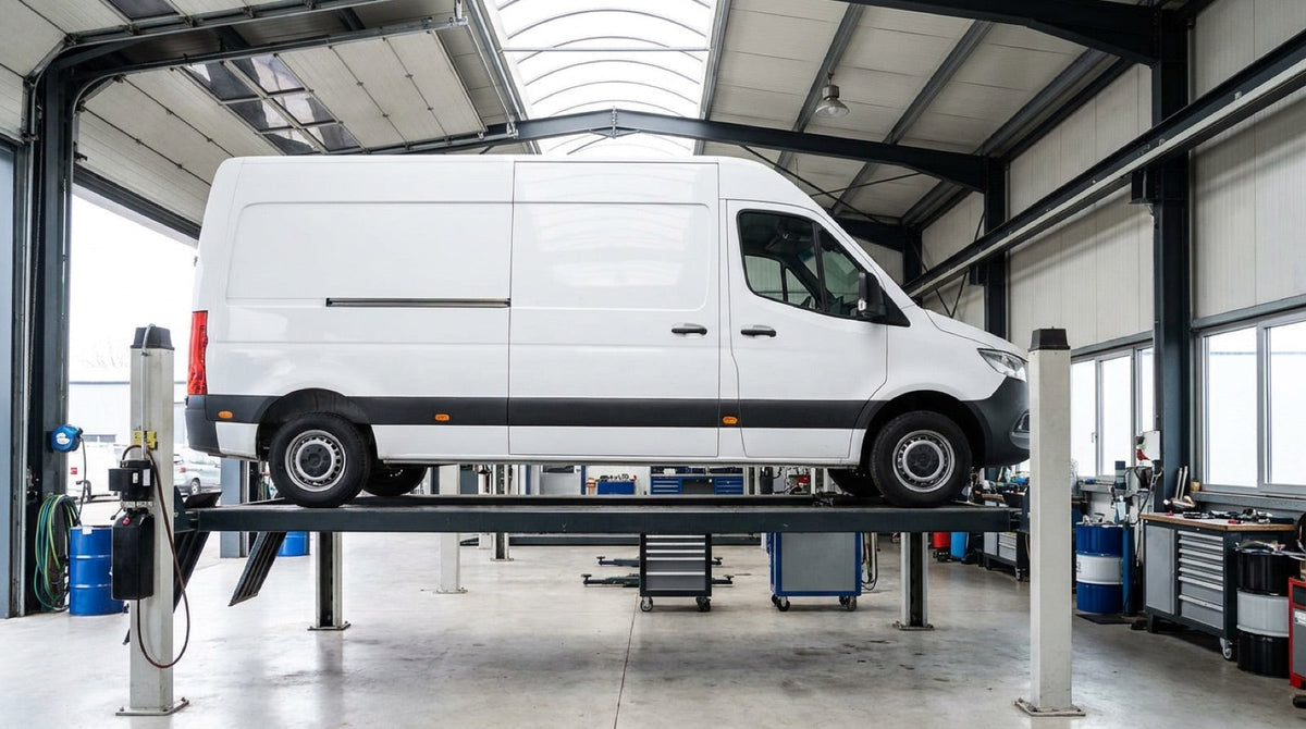 Panel van raised on a four-post lift in a commercial workshop