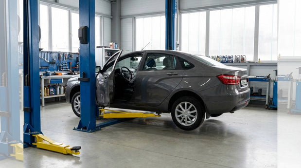 Car raised on an asymmetric two-post lift with the driver's door open between the columns