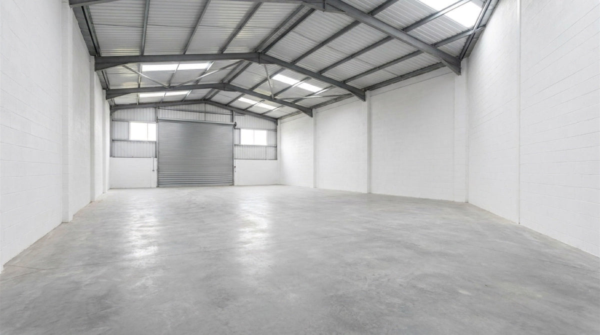 Empty industrial unit with bare concrete floor ready to be fitted out as a workshop
